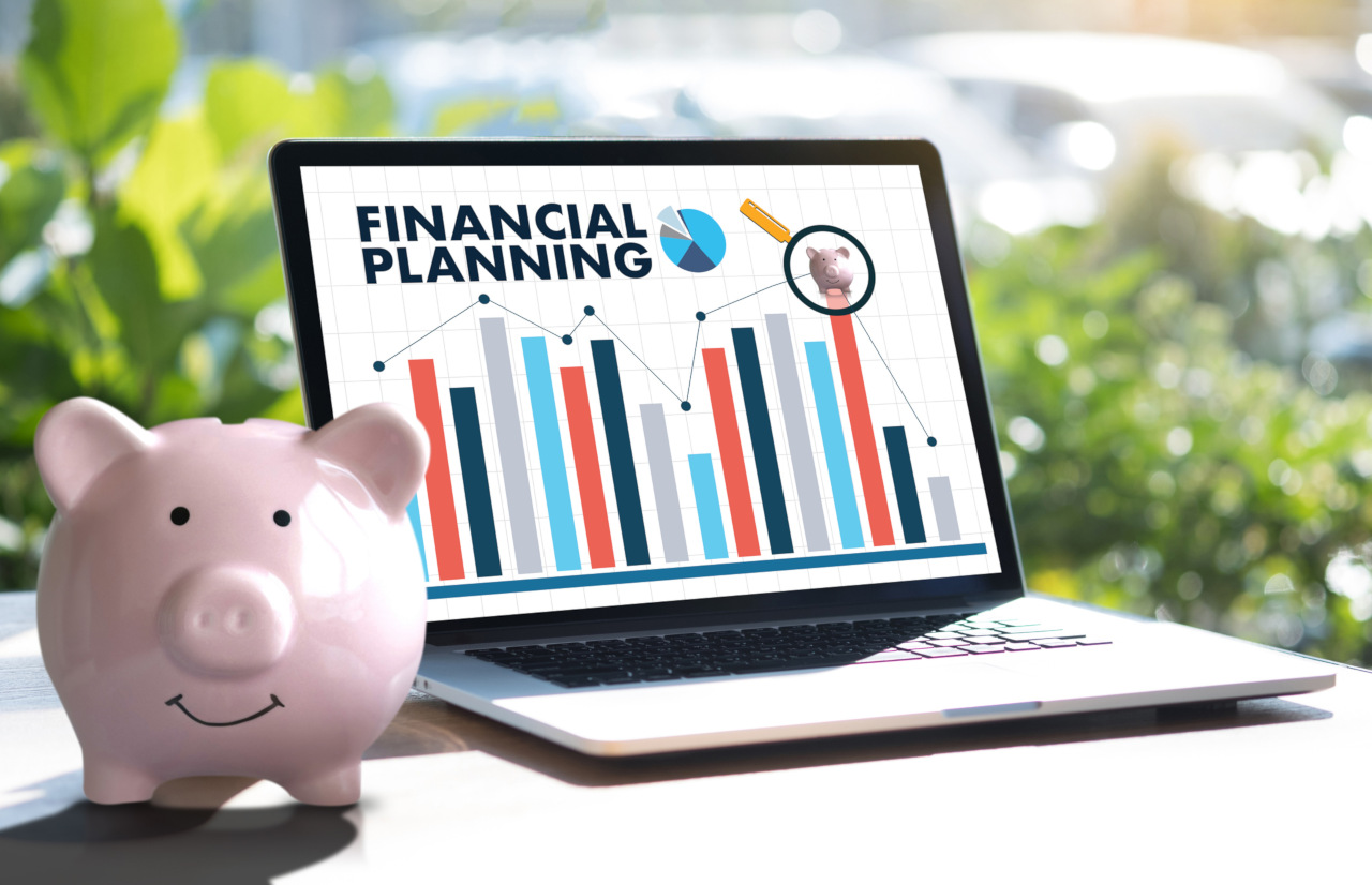 Smiling piggy bank with laptop computer display of "Financial Planning"